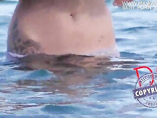 Witness a young girl swimming in panties at the beach in a steamy porn video